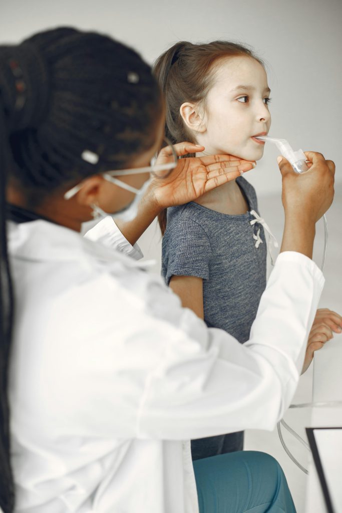 A girl receives a treatment from a medical professional in a clinic setting.