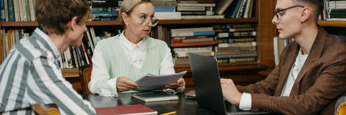 A focused group discussion among adults in a library with bookshelves.